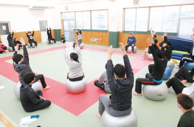 バランスボールを使って患部の機能回復・運動療法を学ぶ、柔道整復後療法演習の授業風景
