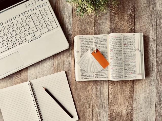 デスクでスポーツトレーナーになるための勉強をしている写真です。