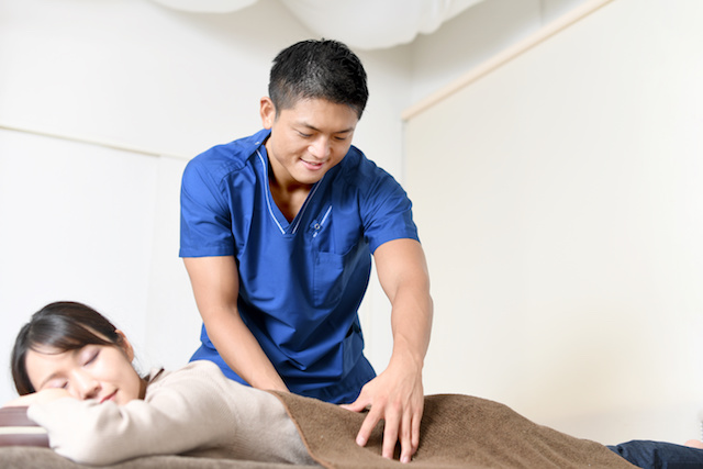 スポーツトレーナーががマッサージしている写真です。