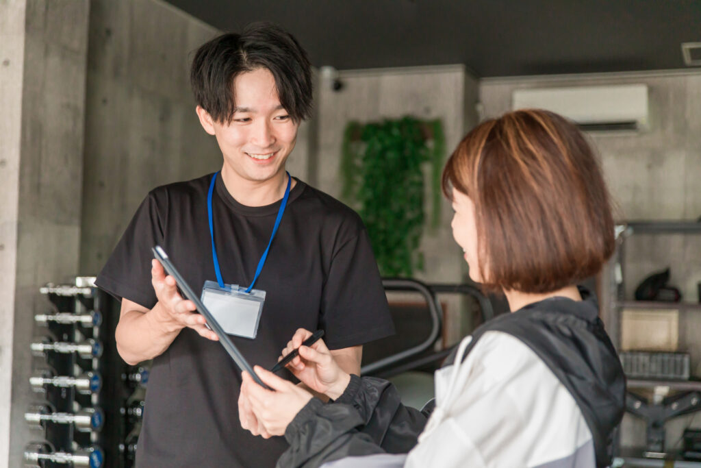 パーソナルジムでトレーナーがヒアリングをしている写真です。