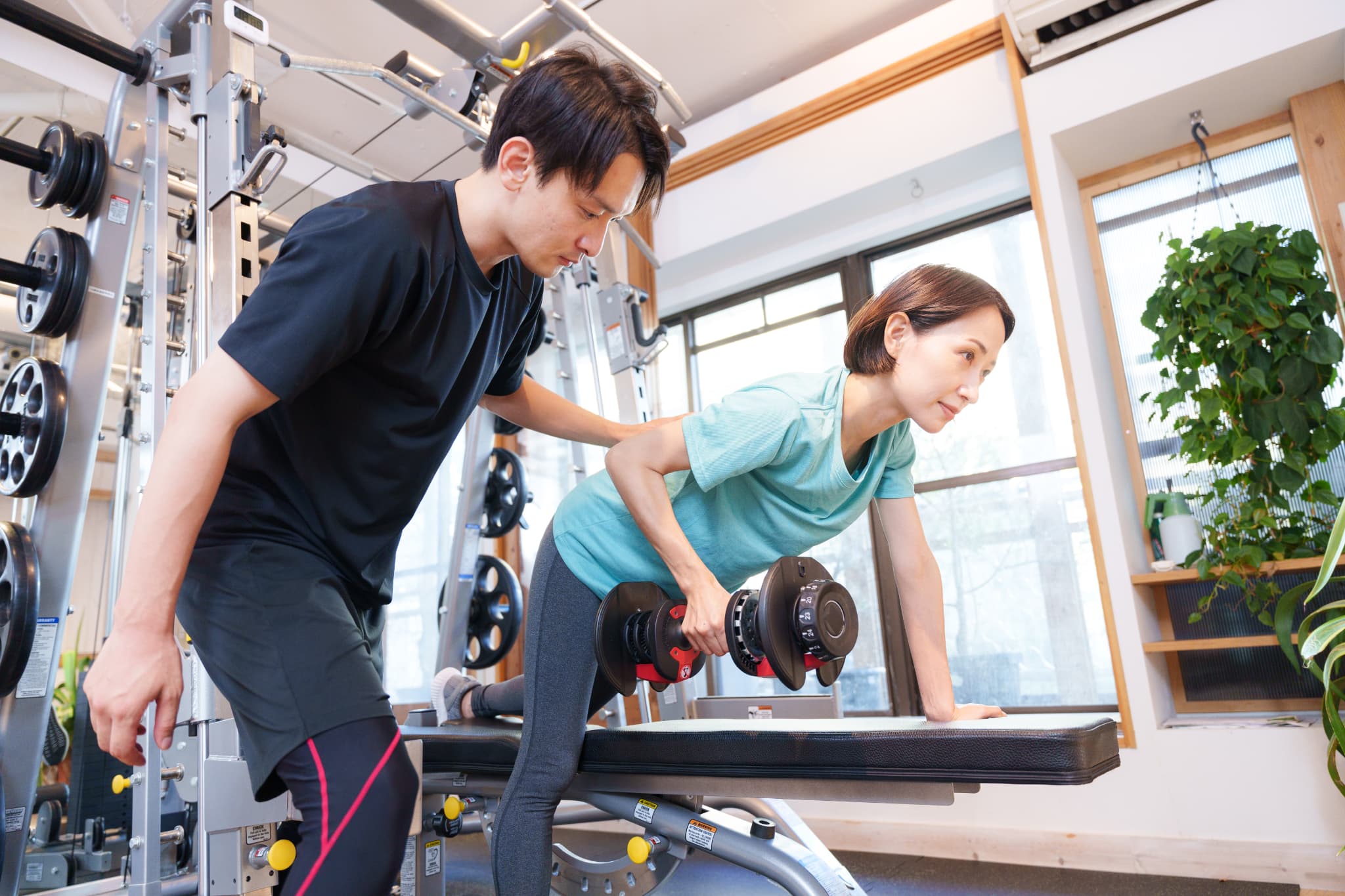 スポーツトレーナーが補助をしている様子の写真です。